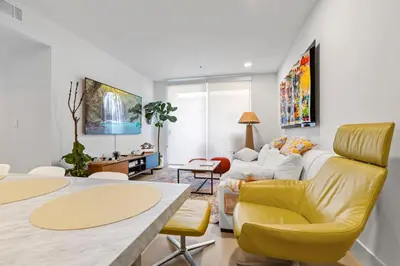 a living room with a yellow chair and a couch at 9 Advantages Center Santa Manica in Los Angeles