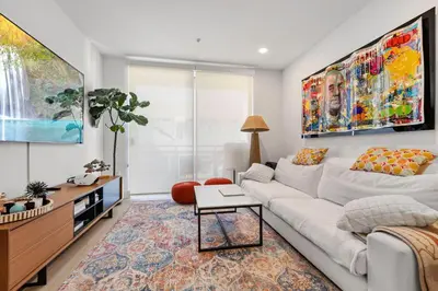a living room with a white couch and a large painting at 9 Advantages Center Santa Manica in Los Angeles