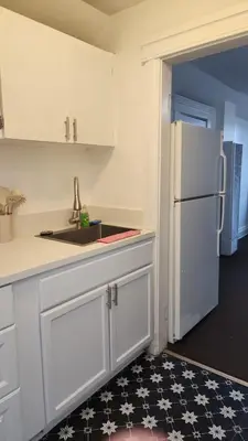 a kitchen with a sink and a white refrigerator at Eight Street Apartments in Long Beach