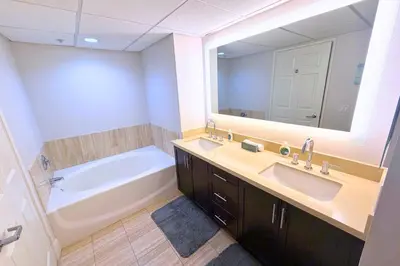 a bathroom with a tub and a sink and a mirror at Super Quiet Apartment In Full Service Bldg near UCLA in Los Angeles