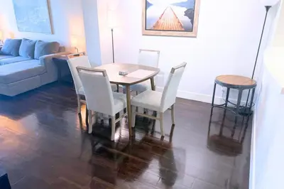 a living room with a table and chairs and a couch at Super Quiet Apartment In Full Service Bldg near UCLA in Los Angeles