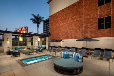 a patio with a pool with chairs and an umbrella at Super Quiet Apartment In Full Service Bldg near UCLA in Los Angeles