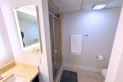 a bathroom with a shower and a sink and a mirror at Super Quiet Apartment In Full Service Bldg near UCLA in Los Angeles
