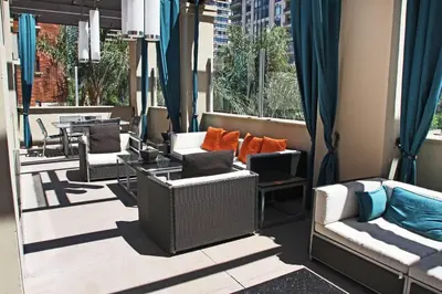 a row of chairs and tables on a balcony with windows at Super Quiet Apartment In Full Service Bldg near UCLA in Los Angeles