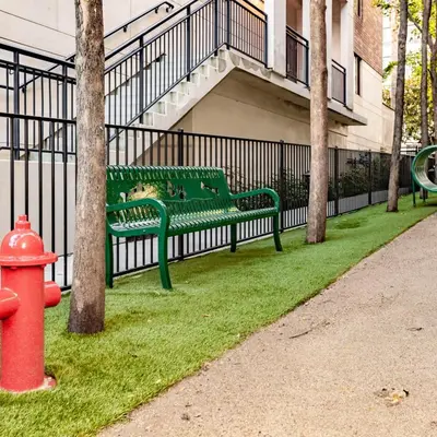 a green park bench next to a fence with a fire hydrant at Stylish 2 Bed 2.5 Bath Condo Near Beverly Hills. in Los Angeles