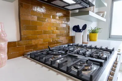 a black stove top in a kitchen with a brick wall at Luxury 2br 2ba Beverly Hills Near Cedars Sinai in Los Angeles