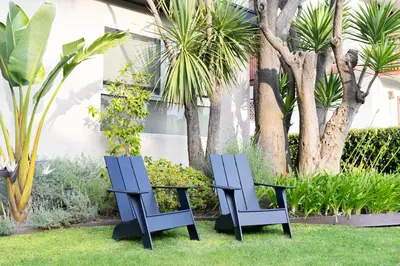 two blue chairs and a table in the grass at Luxury 2br 2ba Beverly Hills Near Cedars Sinai in Los Angeles