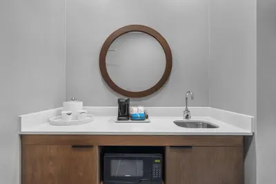 a bathroom with a sink and a microwave and a mirror at Hampton Inn & Suites Bakersfield Central in Bakersfield