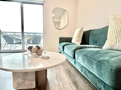 a living room with a green couch and a table at NEW One Bedroom Penthouse, Silver Lake + Parking! in Los Angeles