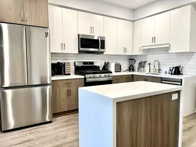 a kitchen with a stainless steel refrigerator and wooden cabinets at NEW One Bedroom Penthouse, Silver Lake + Parking! in Los Angeles