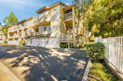 an apartment building with a white fence and trees at Thousand Oaks 2br near shopping dining bars LAX-1157 in Oak Park