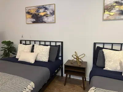 a bedroom with two beds and a table and paintings at Hollywood Universal Studios Apartment FREE parking in Los Angeles
