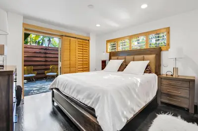 a bedroom with a large bed with a wooden headboard at Edwin by AvantStay Hollywood Hills Luxury Pool in Los Angeles