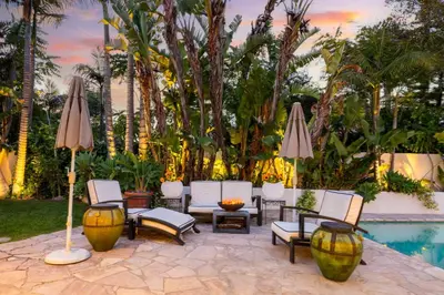 a patio with chairs and umbrellas next to a pool at Edwin by AvantStay Hollywood Hills Luxury Pool in Los Angeles