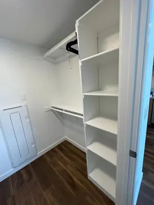 a white closet with white shelves and a wooden floor at Cozy Loft Sunset FRRE WIFI and DESIGNATED Parking in Los Angeles