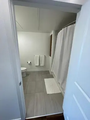 a bathroom with a toilet and white towels at Cozy Loft Sunset FRRE WIFI and DESIGNATED Parking in Los Angeles