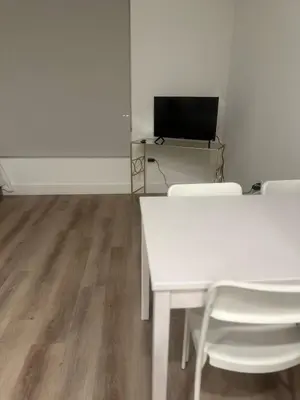 a room with a white table and chairs and a television at Cozy Loft Sunset FRRE WIFI and DESIGNATED Parking in Los Angeles