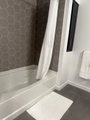 a bathroom with a bath tub with a shower curtain at Cozy Loft Sunset FRRE WIFI and DESIGNATED Parking in Los Angeles