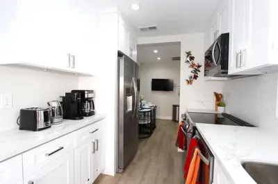 a kitchen with white cabinets and a stainless steel refrigerator at NEW! 2-Bedroom Fontana Guest House close to Kaiser Permanente in Fontana