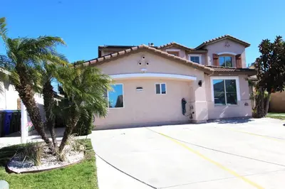 a house with a palm tree in front of it at NEW! 2-Bedroom Fontana Guest House close to Kaiser Permanente in Fontana