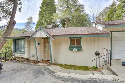 a white house with a green door and a driveway at Crestline Home with Private Hot Tub Steps to Lake! in Crestline