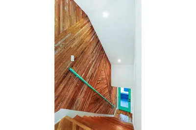 a staircase with wood paneling and a green rail at Peace Palace 4803 in Los Angeles
