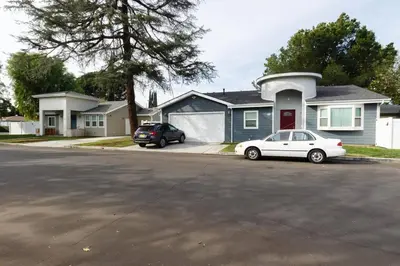 a white car parked in front of a house at Lake Balboa 7 Bedroom 5 Bathroom Compound in Los Angeles