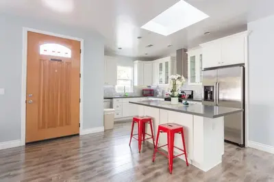 a kitchen with two red stools at a counter at Lake Balboa 7 Bedroom 5 Bathroom Compound in Los Angeles