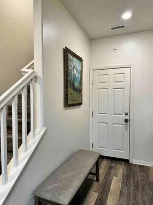 a hallway with a bench next to a white door at 3 Bedroom Townhome with Large Living Area in Downey