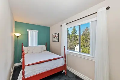 a bedroom with a bed and a large window at Large Comfy Family cabin-Great Kitchen, Pool Table, Pets welcome in Lake Arrowhead