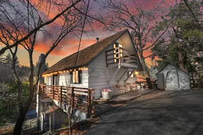 a cabin in the woods at sunset at Large Comfy Family cabin-Great Kitchen, Pool Table, Pets welcome in Lake Arrowhead