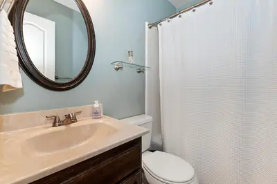 a bathroom with a sink and a toilet and a mirror at Large Comfy Family cabin-Great Kitchen, Pool Table, Pets welcome in Lake Arrowhead