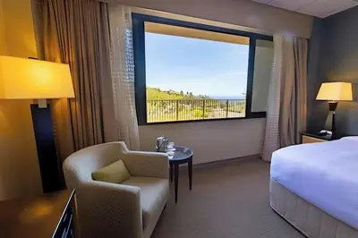 a hotel room with a bed and a chair and a window at Villa Graziadio Executive Center at Pepperdine University in Malibu
