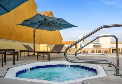 a swimming pool with an umbrella and a table and chairs at Stylish in Sunny Santa Monica walk to Beach & Pier in Los Angeles