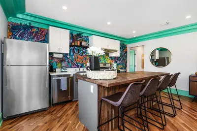 a kitchen with a refrigerator and a counter with stools at Peace Palace 56 in Los Angeles