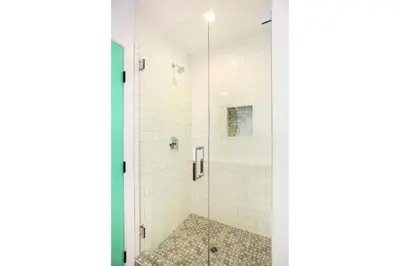 a bathroom with a shower with white tiles at Peace Palace 56 in Los Angeles