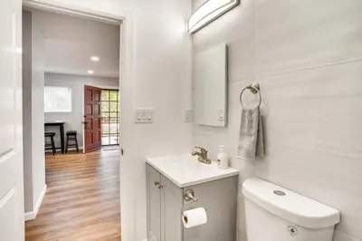 a white bathroom with a sink and a toilet at Rental with Pool Access about 8 Mi to Disneyland in La Palma