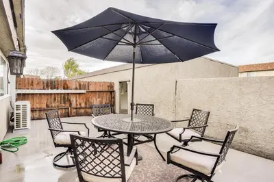 a table and chairs with an umbrella on a patio at Rental with Pool Access about 8 Mi to Disneyland in La Palma