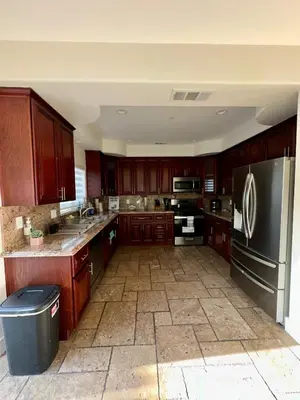 a kitchen with wooden cabinets and a stainless steel refrigerator at Qazaq Hostel in Los Angeles