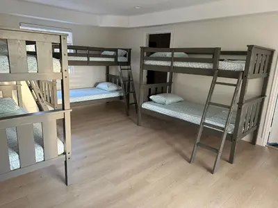 a room with three bunk beds and a wooden floor at Qazaq Hostel in Los Angeles