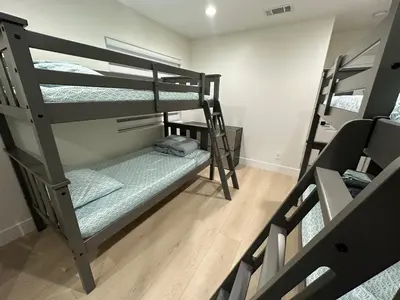 a room with three bunk beds in a room at Qazaq Hostel in Los Angeles