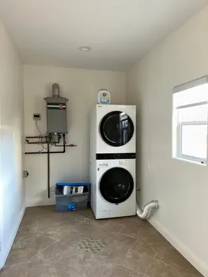 a washer and dryer in a corner of a room at Qazaq Hostel in Los Angeles