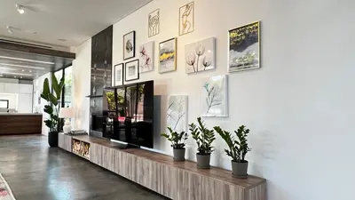 a living room with a tv and potted plants on a wall at Luxurious Venice Oasis Home in Los Angeles