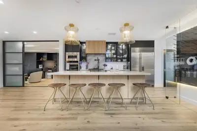 a kitchen with three bar stools and a counter at Erwin Estate in Los Angeles
