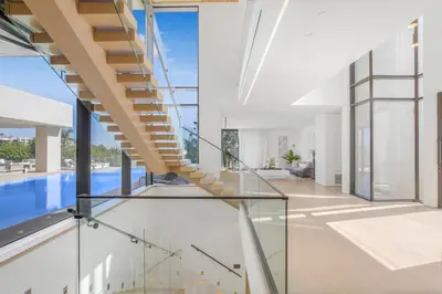 a glass staircase in a house with a swimming pool at Swallow Sanctuary in Los Angeles