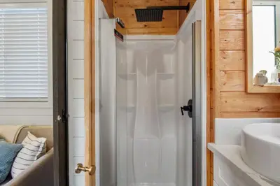 a bathroom with a shower and a sink at Tiny Farmhouse on Wheels in Santa Clarita