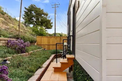 a garden with stairs on the side of a house at Tiny Farmhouse on Wheels in Santa Clarita