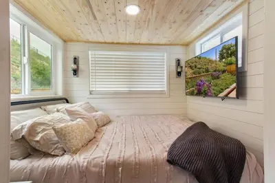 a bedroom with a bed in a room with a window at Tiny Farmhouse on Wheels in Santa Clarita
