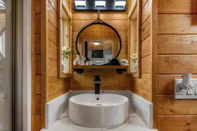 a bathroom with a sink and a mirror at Tiny Farmhouse on Wheels in Santa Clarita