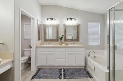 a bathroom with two sinks and a tub and a toilet at 5BR 3BA Home - King Beds - Fast Wifi home in Victorville